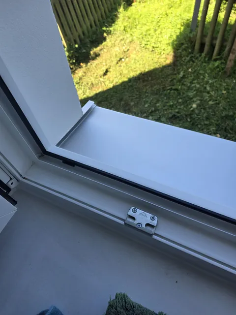 Gereinigter Fensterfalz und weiße Außenfensterbank am geöffneten Fenster