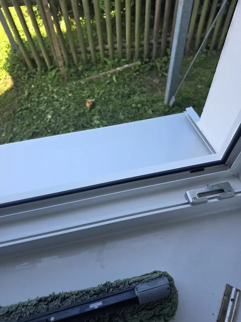 Detail der gereinigten Fensterrahmen und Fensterbank mit bereitliegendem Einwascher