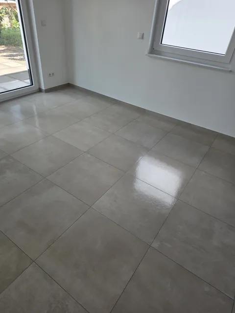 Gereinigter Fliesenboden im Wohnraum mit sichtbaren Lichtreflexionen