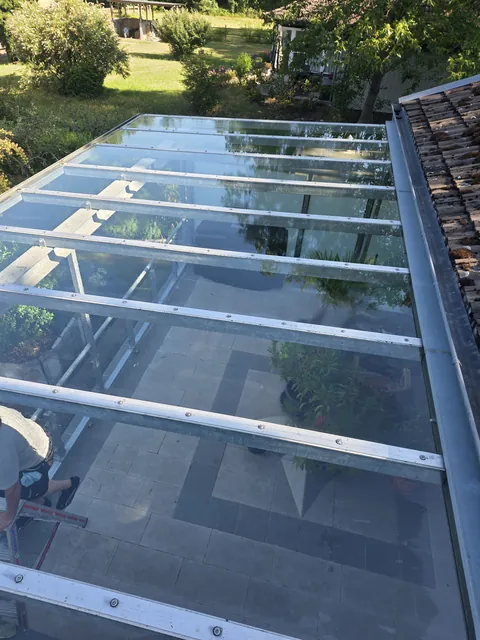 Gereinigte Glasflächen einer Terrassenüberdachung mit Blick in den Garten
