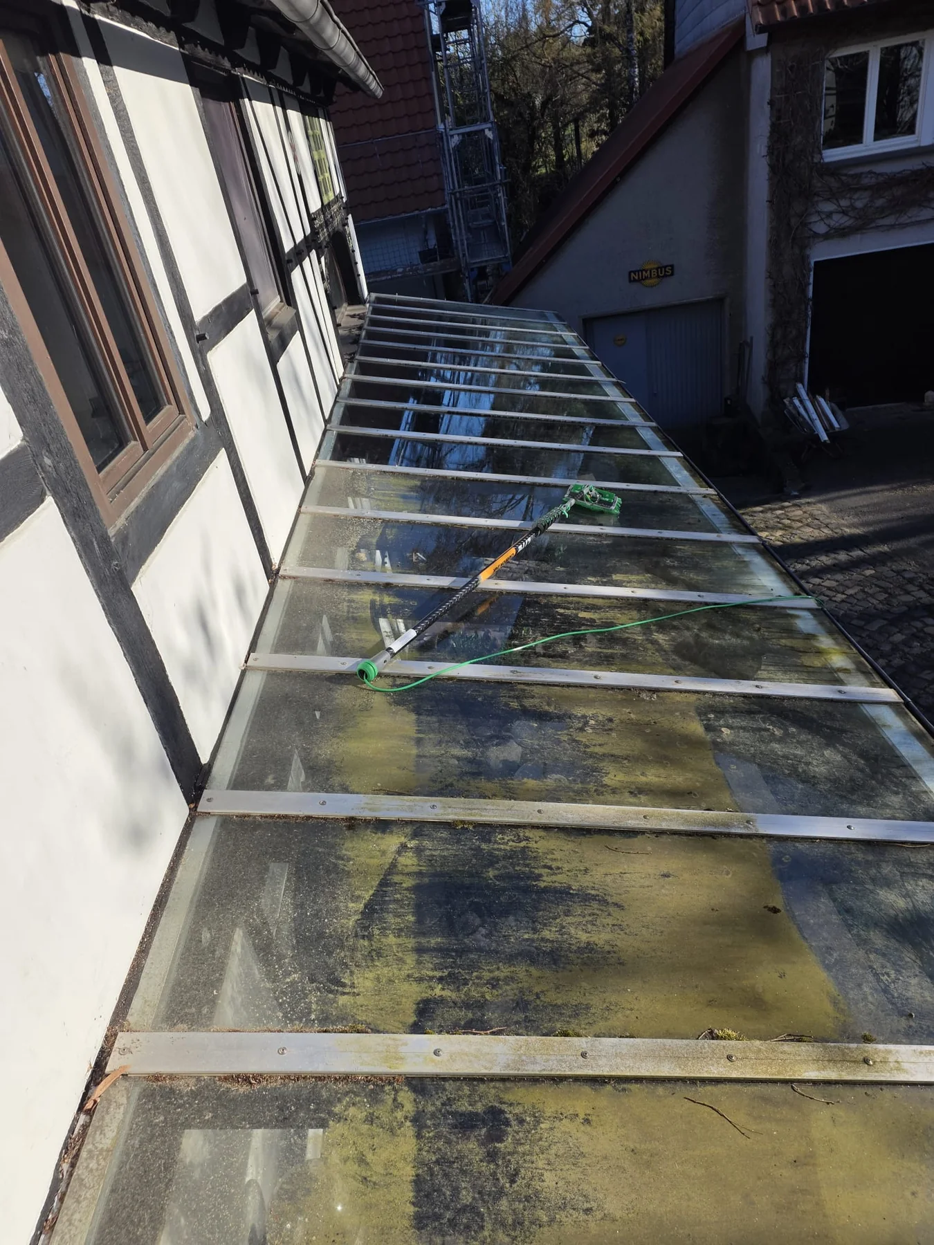 Glasdach mit Algen- und Schmutzbelag vor der Reinigung