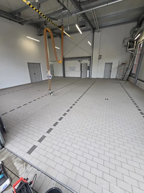 Gereinigter Fliesenboden der Fahrzeughalle nach der maschinellen Bodenreinigung