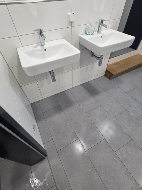 Gereinigte Waschbecken und Fliesenflächen im Sanitärbereich