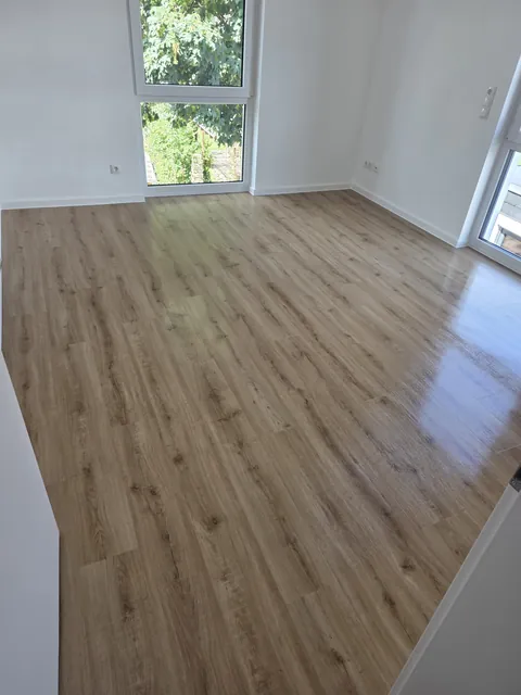 Gereinigter Wohnraumboden in Holzoptik mit bodentiefem Fenster